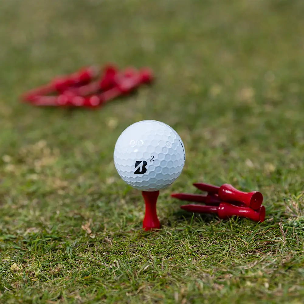 A bridgestone golf ball positioned on a PTS® Step Tees in grass turf.