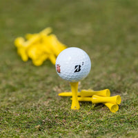 A bridgestone golf ball positioned on a PTS® Step Tees in grass turf.