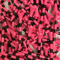 Close-up of pink and black golf tees scattered on a white background
