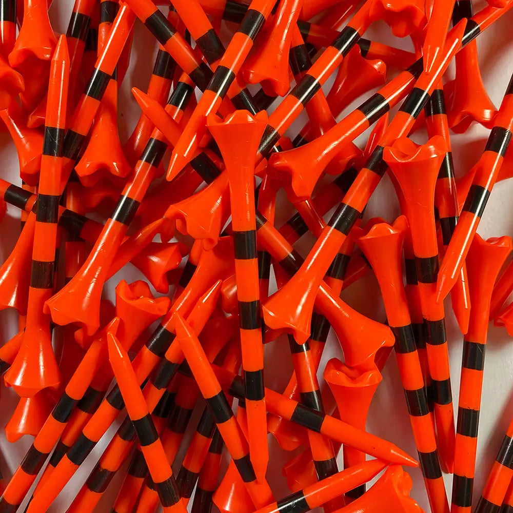 Pile of orange and black striped golf tees on a white background