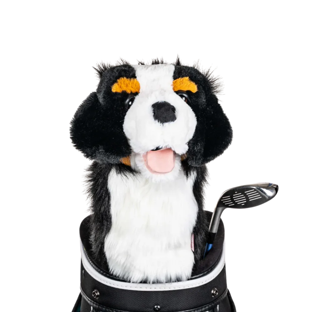 A plush dog headcover peeks out from a golf bag, featuring a fluffy design with black and white markings.