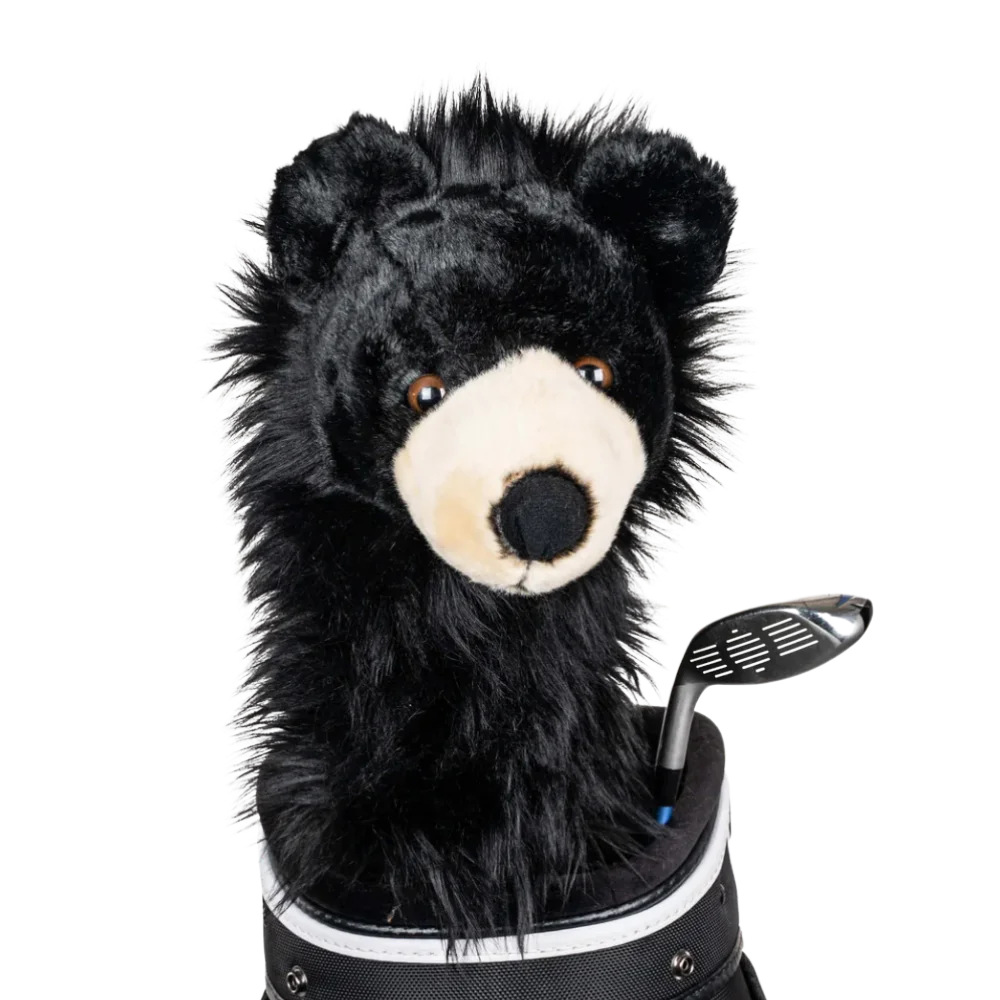 A black bear-shaped golf club head cover sitting in a golf bag, with a club peeking out.