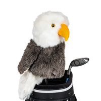 An eagle-shaped golf club head cover sitting in a golf bag, with a club peeking out.