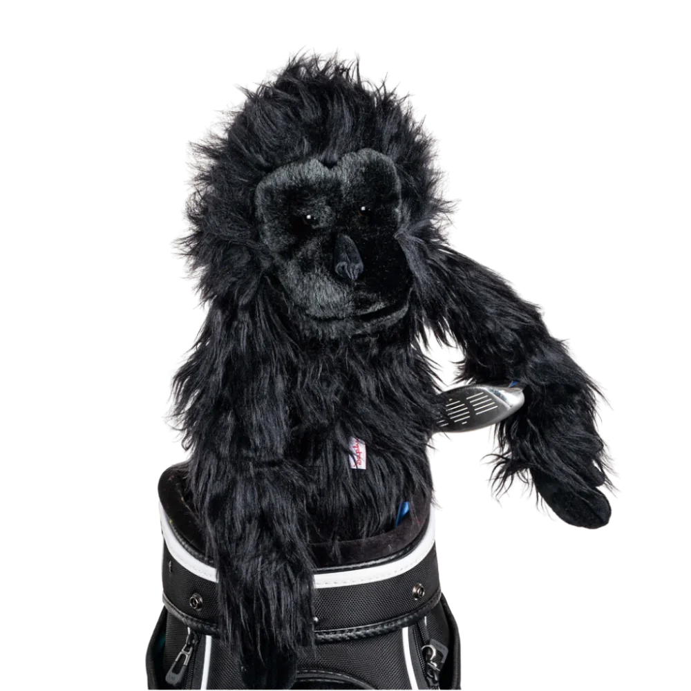A gorilla-shaped golf club head cover sitting in a golf bag, with a club peeking out.
