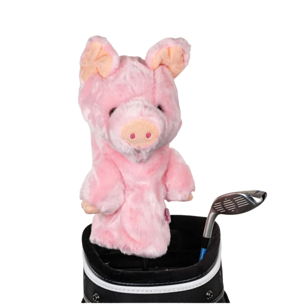 A pig-shaped golf club head cover sitting in a golf bag, with a club peeking out.