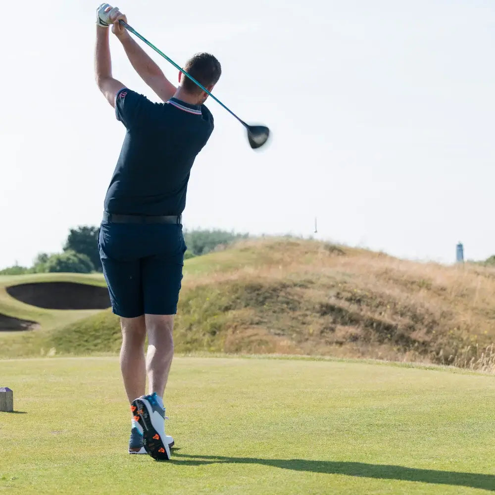 A golfer taking a swing on a golf course.