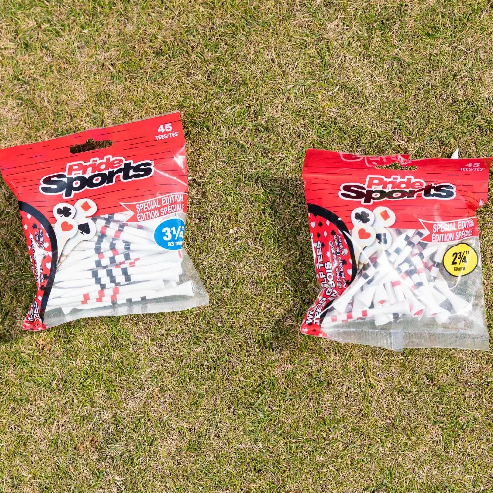 Two packages of pride sports golf tees on grass featuring special edition playing cards design, one containing 45 pieces of 3½ inch tees and the other containing 45 pieces of 2¾ inch tees.