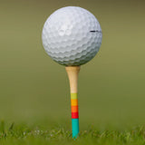 Close-up of golf ball on Honors Collection bamboo tee with sunrise gradient stripes.