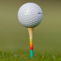 Close-up of golf ball on Honors Collection bamboo tee with sunrise gradient stripes.