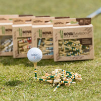Mulitple nova bamboo packages sitting behind a golf ball positioned on a green and yellow nova bamboo tee. 