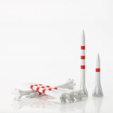 White and red golf tees on a white background