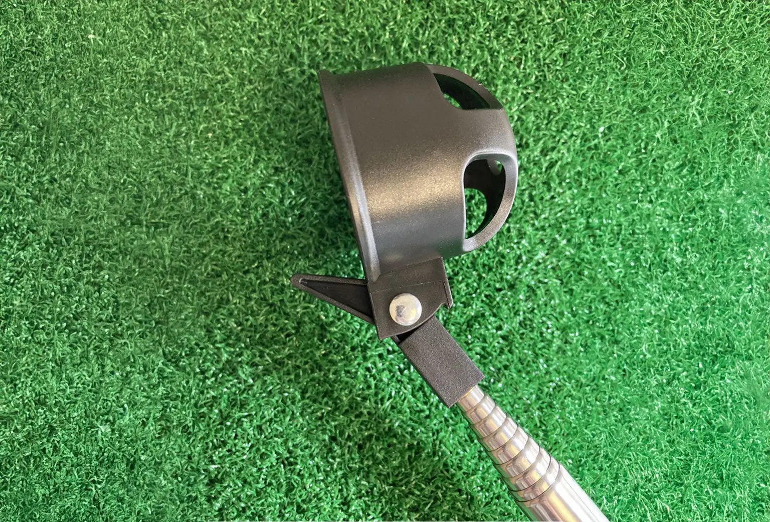 An upclose of a black ball retriever on top of green turf. 