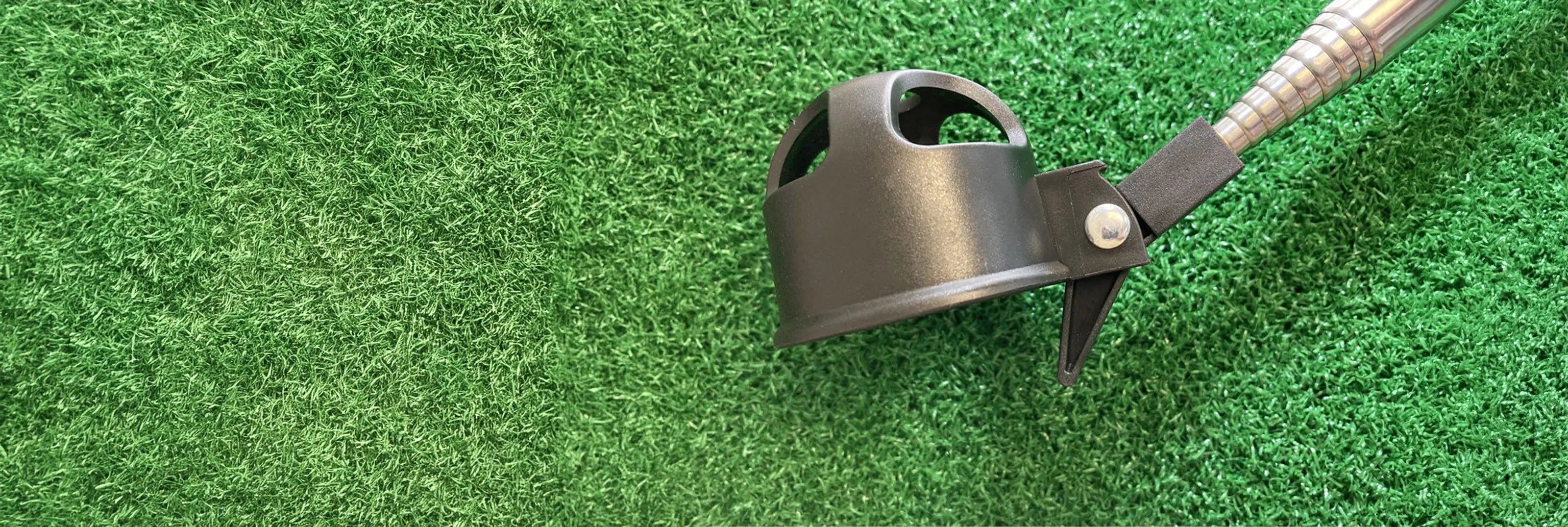 An upclose of a black ball retriever on top of green turf. 