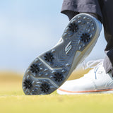 The bottom side of a persons right golf shoe showing the black widow spikes attached. 