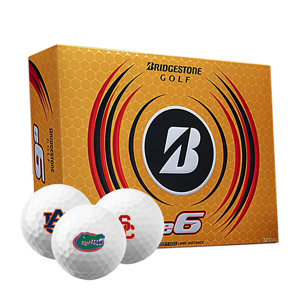Box of Bridgestone e6 golf balls with three golf balls imprinted with different college logos on a white background