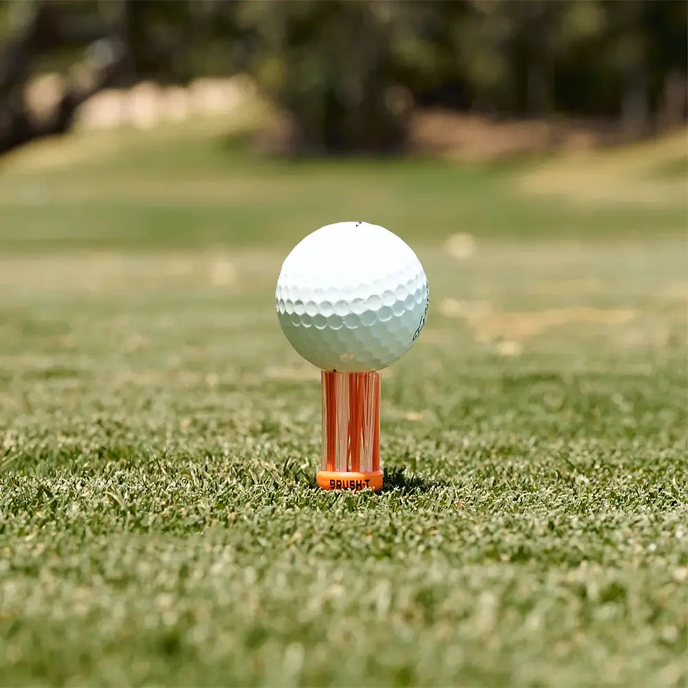 A golf ball positioned an orange oversize BrushT. 