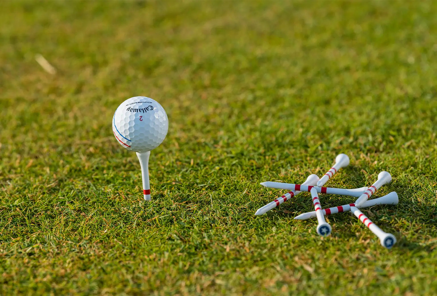A callaway golf ball on top of pride sports custom stars and stripes tees. 