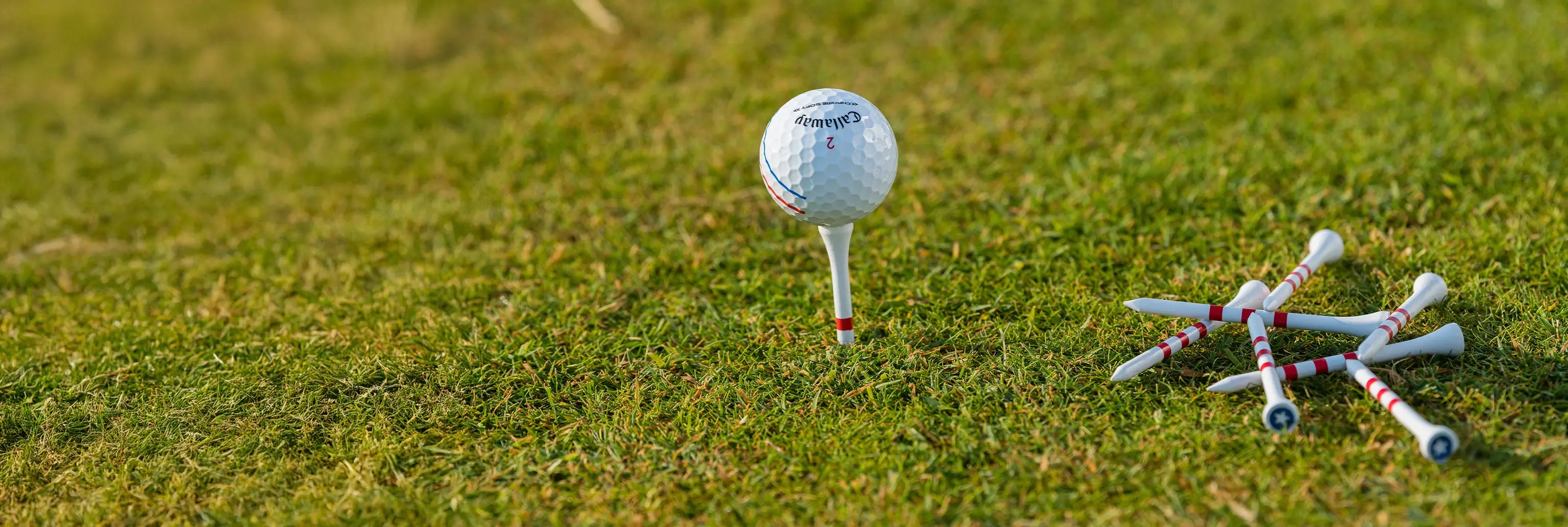 A callaway golf ball on top of pride sports custom stars and stripes tees. 
