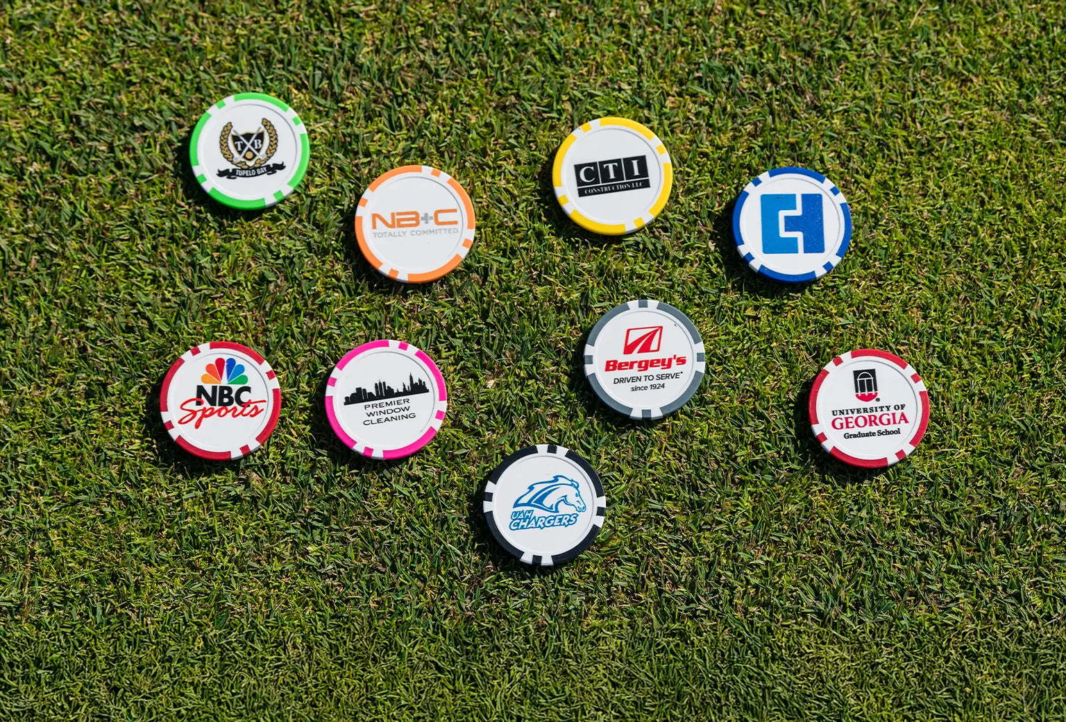 Nine multi-colored custom ball markers with different custom logos and imprints on each marker. 