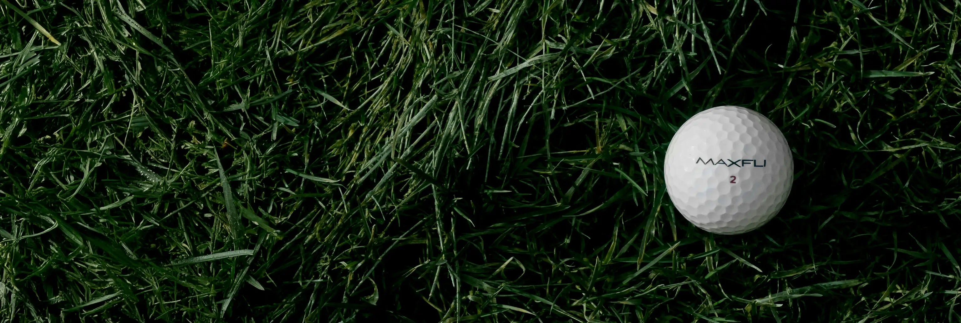 Golf ball with MAXFLI branding on grass