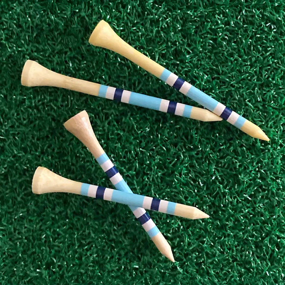 Golf tees with blue and white stripes on a green grass background