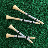 Four golf tees with striped shafts on a green grass background