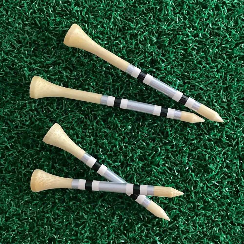 Three golf tees with striped shafts on a green grass background