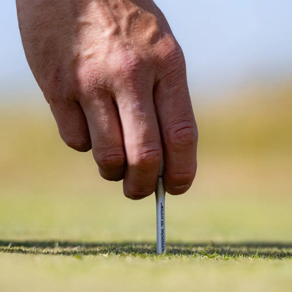 A person inserting the PTS® Titanium Strength™ Wood Golf Tees into turf. 