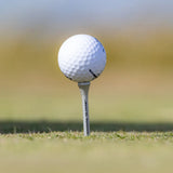 A golf ball sitting on the PTS® Titanium Strength™ Wood Golf Tee.