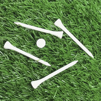Five white 3 1/4" Pride Golf Tee® Packs on green turf. 