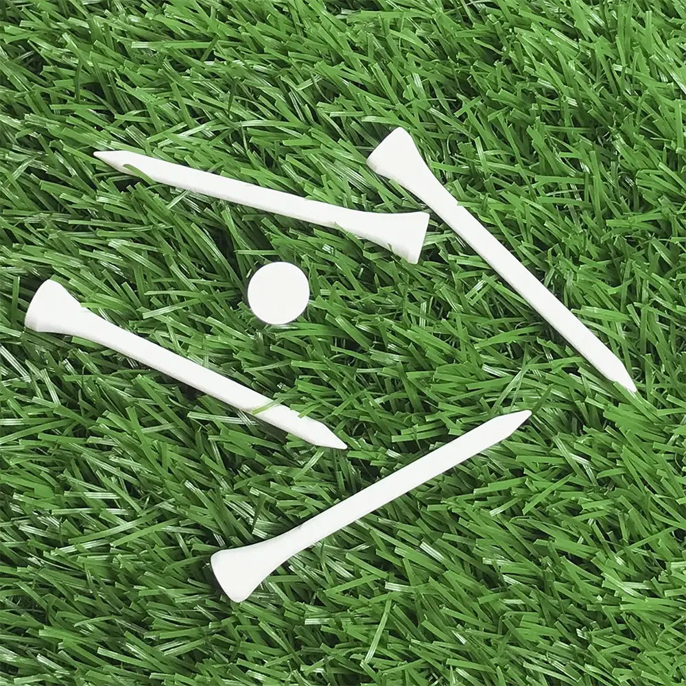 Five white 3 1/4" Pride Golf Tee® Packs on green turf. 
