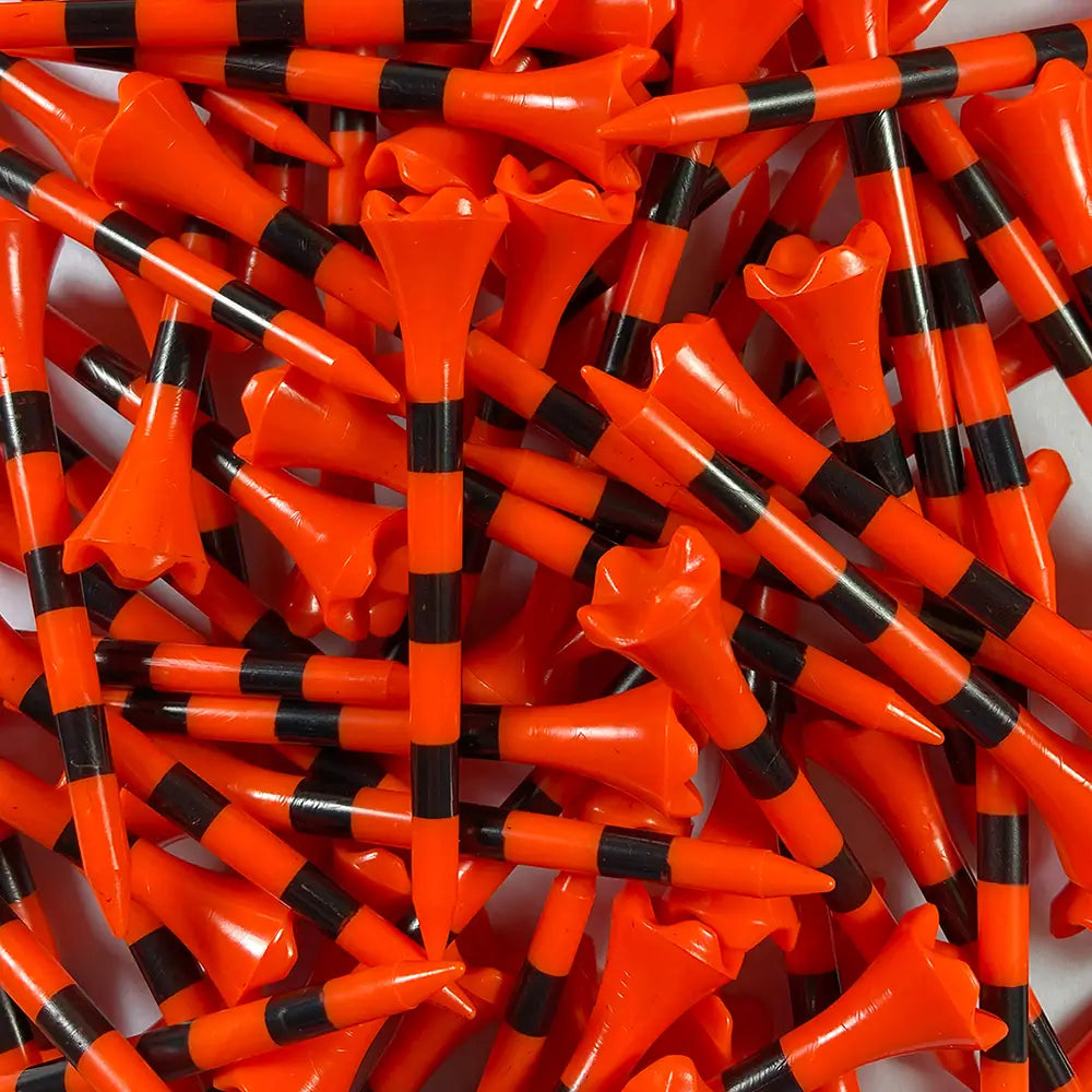 Close-up of a large pile of orange and black striped golf tees.