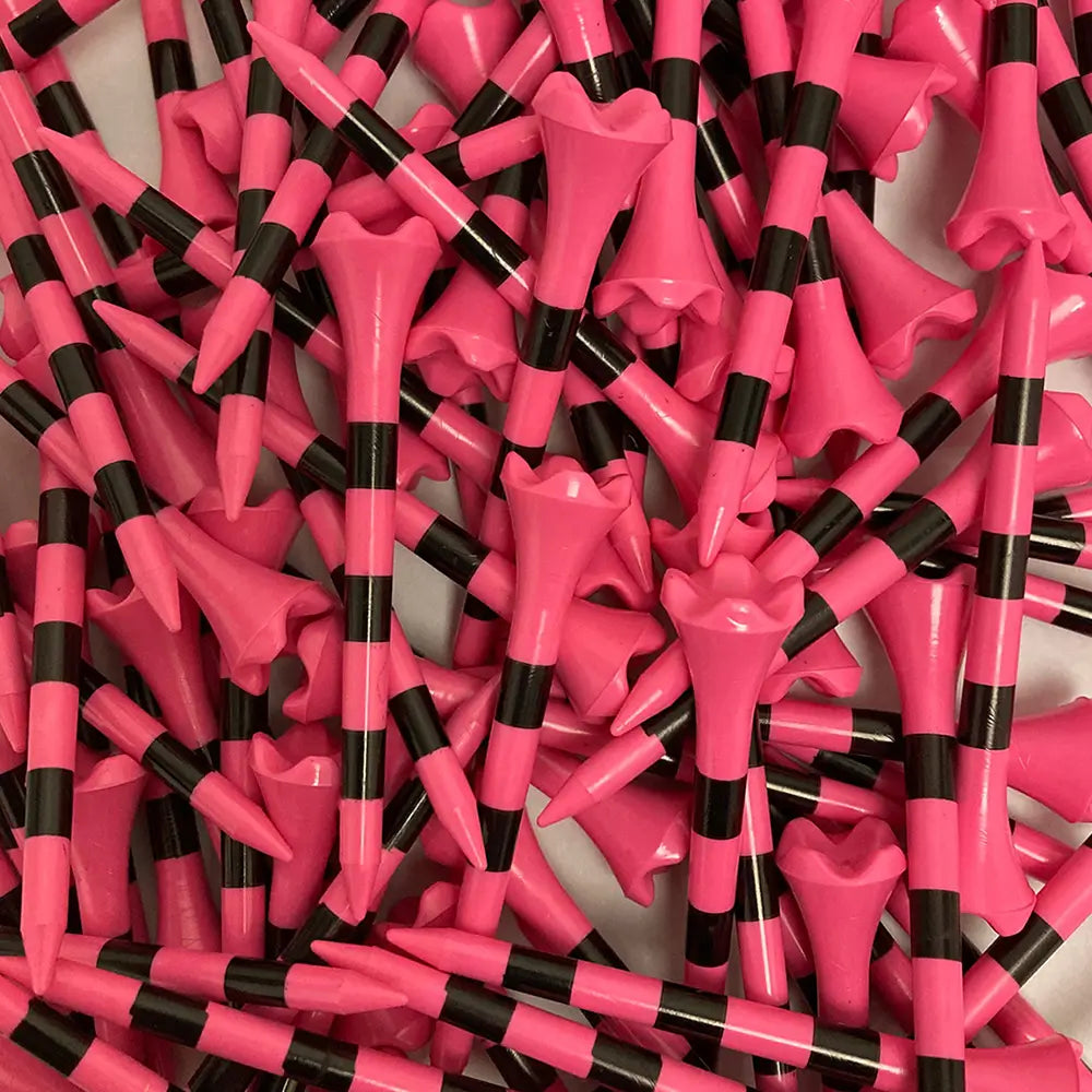 Close-up of pink and black golf tees scattered on a white background