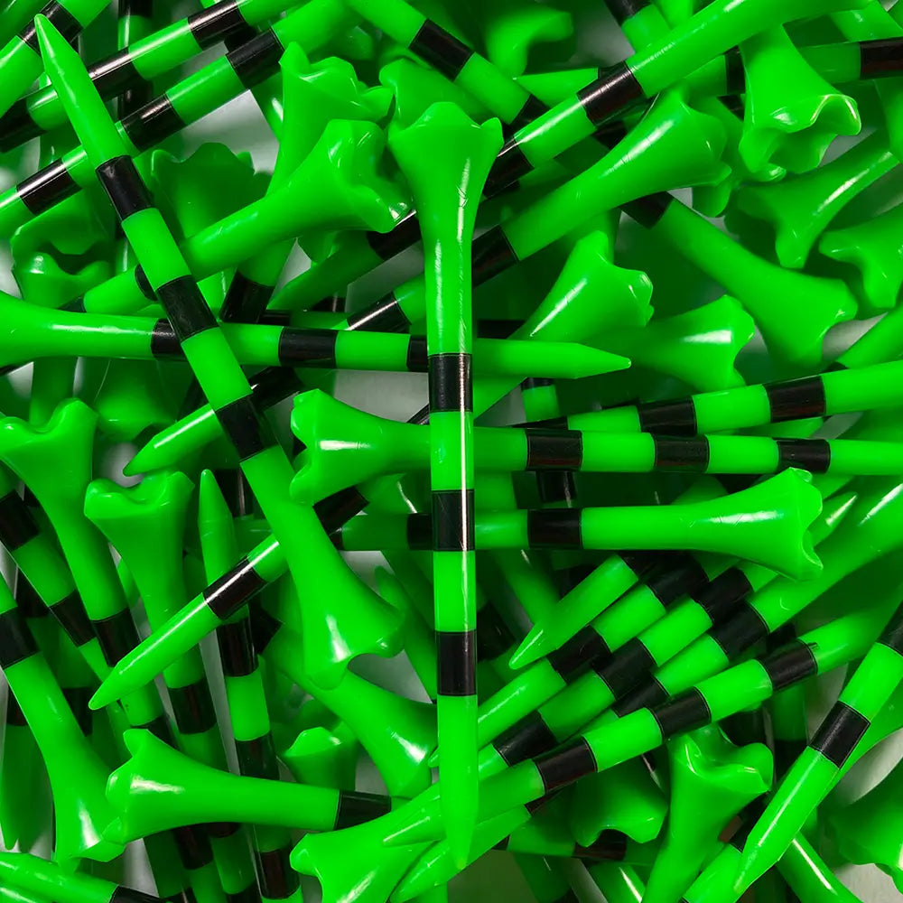 Close-up of green and black golf tees stacked together
