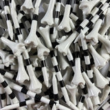 Close-up of a pile of black and white striped golf tees.