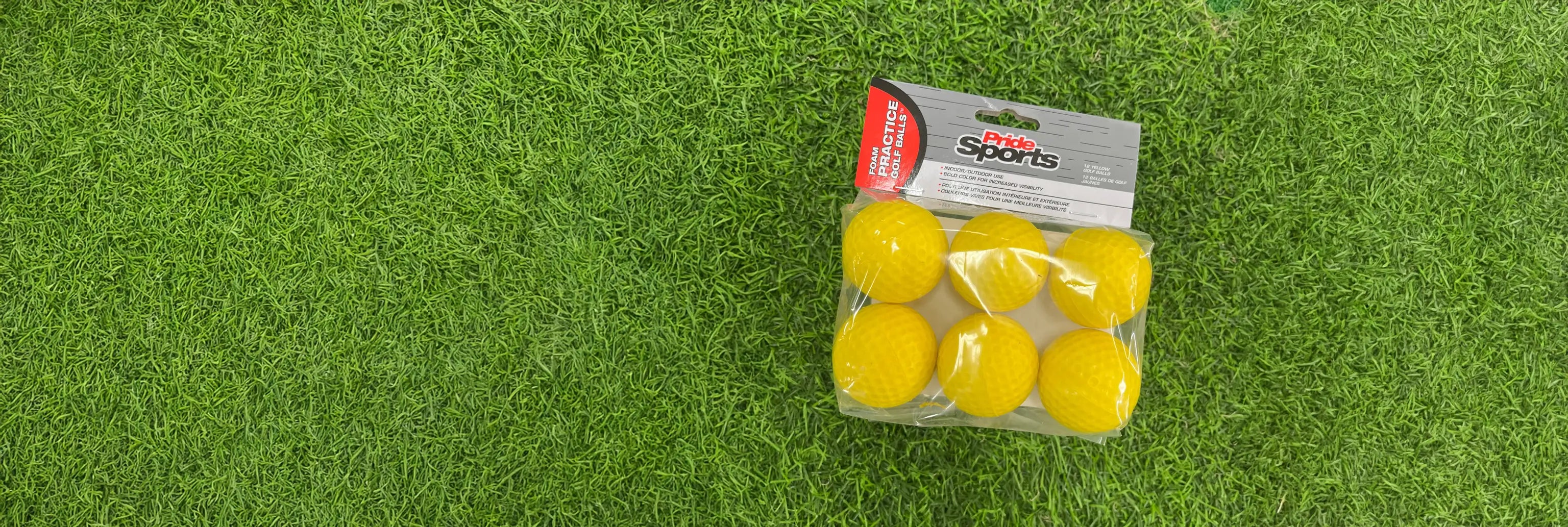 Practice yellow foam ball packaging positioned on a green turf. 