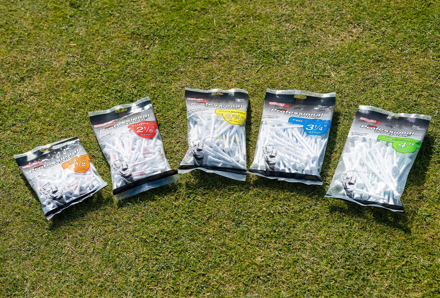Five different Professional Tee System packages on green turf. 