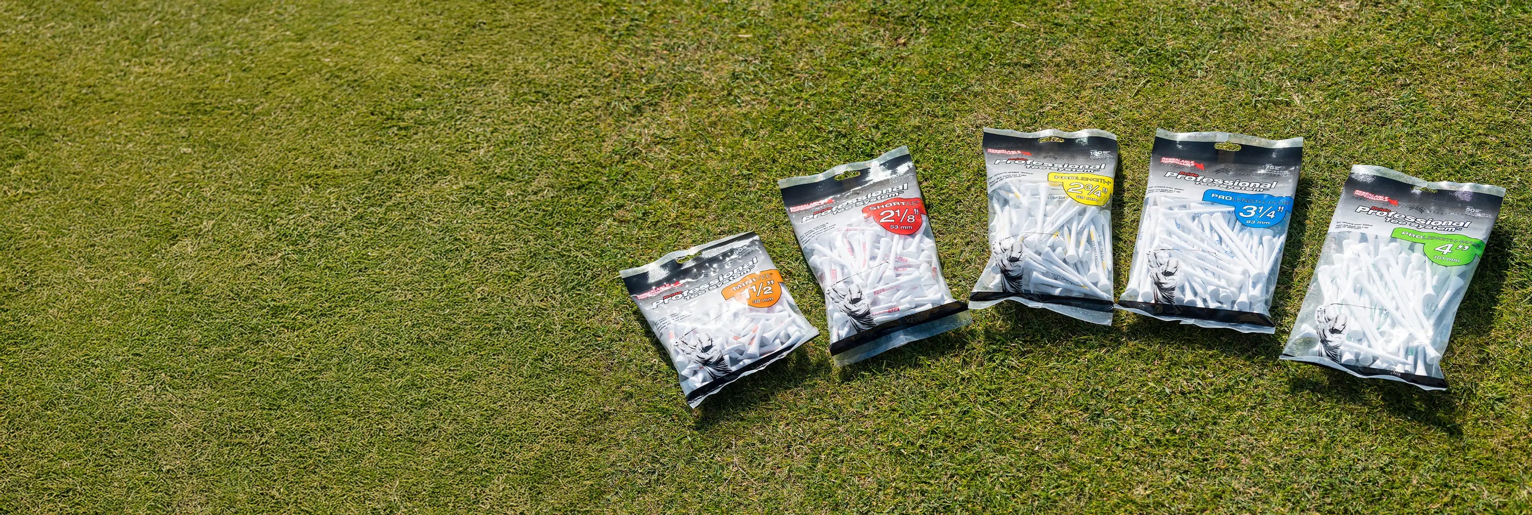 Five different Professional Tee System packages on green turf. 
