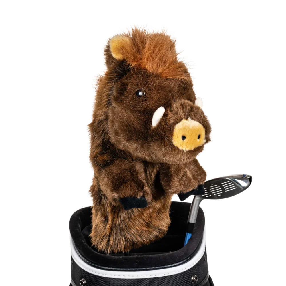 A boar-shaped golf club head cover sitting in a golf bag, with a club peeking out.