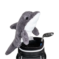 A dolphin-shaped golf club head cover sitting in a golf bag, with a club peeking out.
