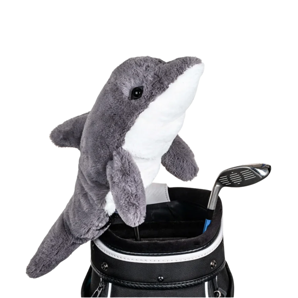 A dolphin-shaped golf club head cover sitting in a golf bag, with a club peeking out.