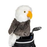 An eagle-shaped golf club head cover sitting in a golf bag, with a club peeking out.