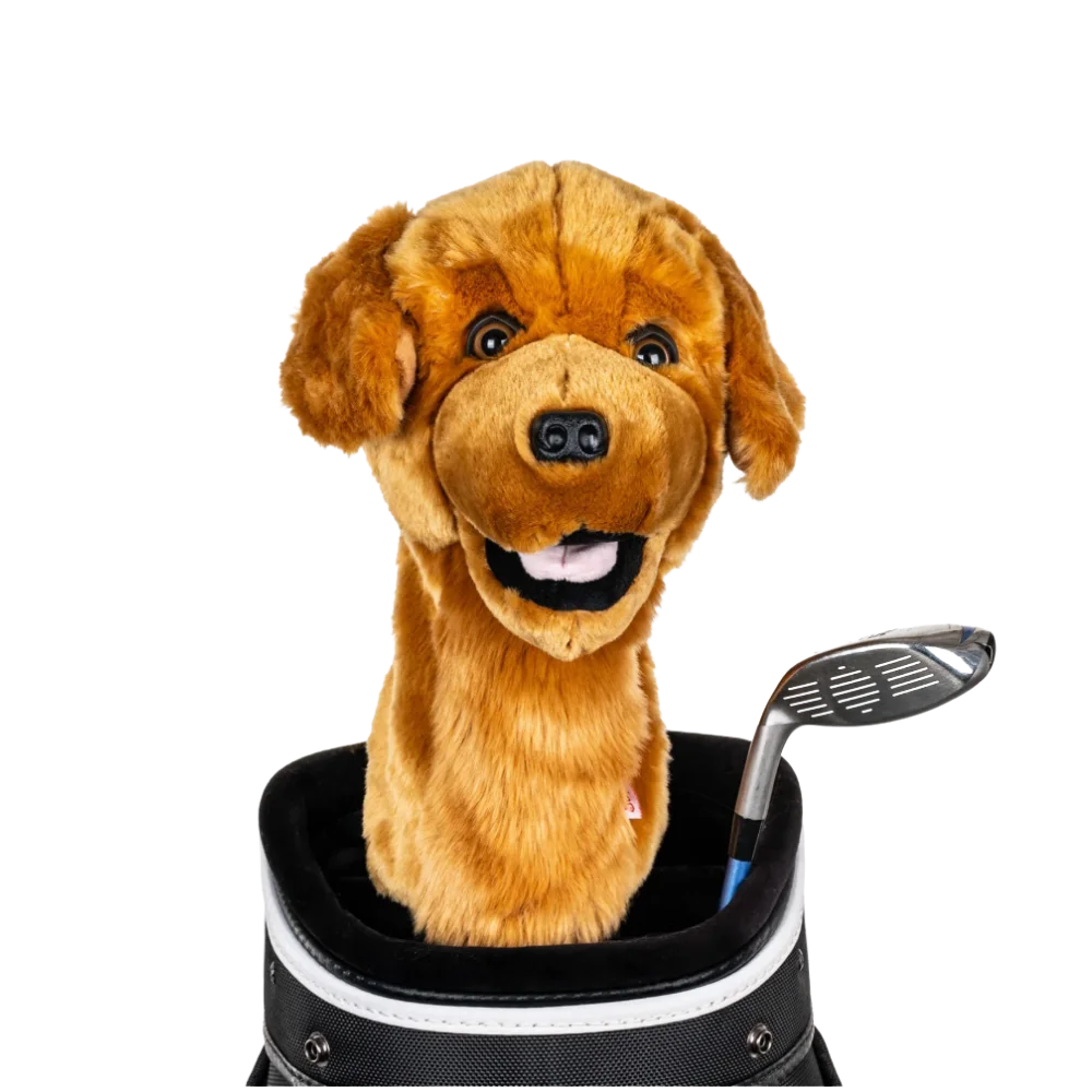 A plush dog golf cover peeks out from a golf bag pocket, beside a golf club.
