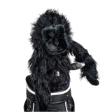 A gorilla-shaped golf club head cover sitting in a golf bag, with a club peeking out.
