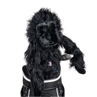 A gorilla-shaped golf club head cover sitting in a golf bag, with a club peeking out.