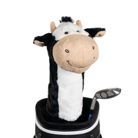 A cow-shaped golf club head cover sitting in a golf bag, with a club peeking out.
