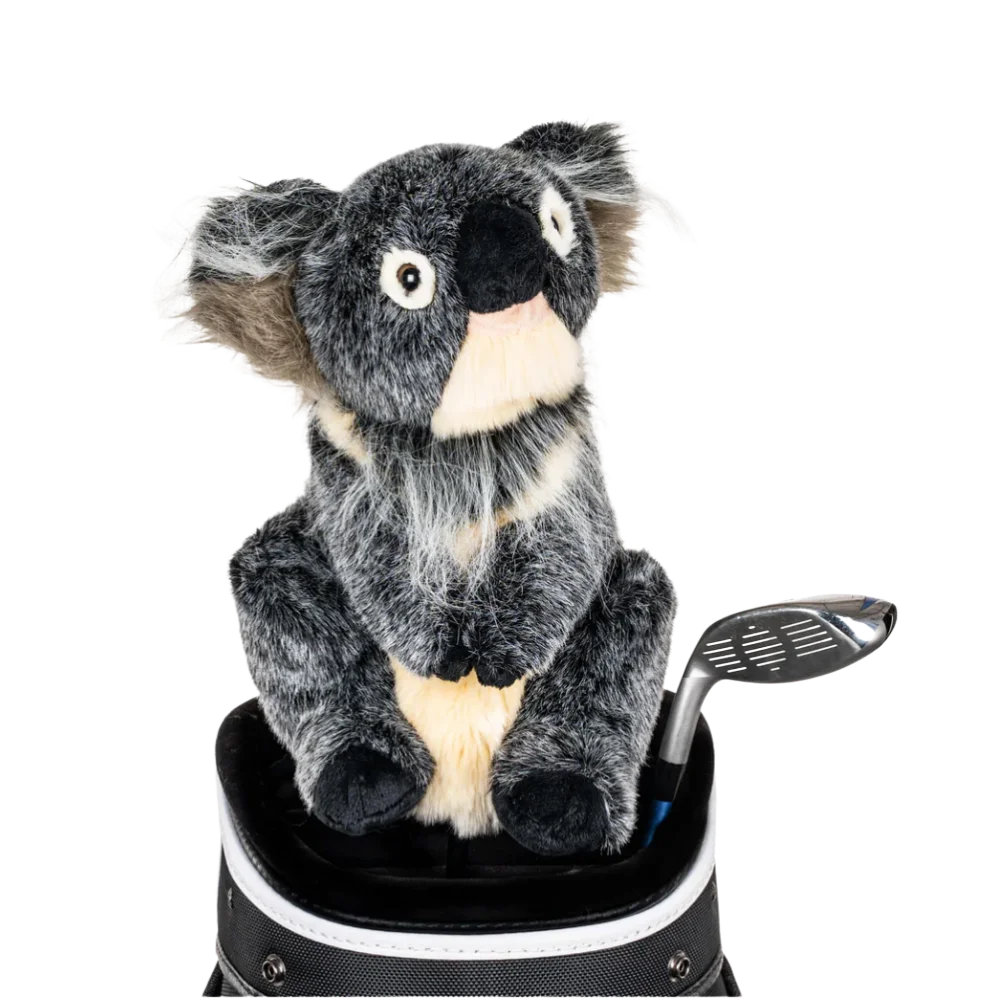 A koala-shaped golf club head cover sitting in a golf bag, with a club peeking out.