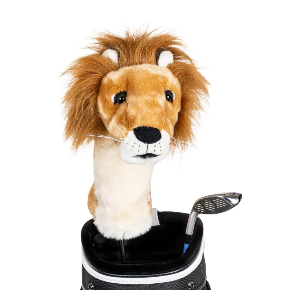 A lion-shaped golf club head cover sitting in a golf bag, with a club peeking out.