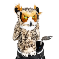 An owl-shaped golf club head cover sitting in a golf bag, with a club peeking out.