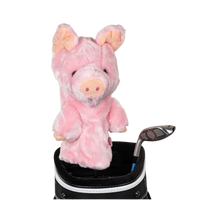 A pig-shaped golf club head cover sitting in a golf bag, with a club peeking out.